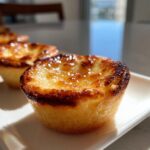 Close-up of a golden-brown baby lemon impossible pie with a slightly caramelized top.