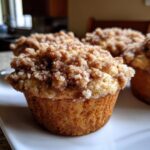 Close-up of a freshly baked coffee cake muffin with a generous crumb topping.