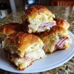 Close-up of delicious Ham and Cheese Sliders with gooey melted cheese oozing out.