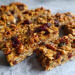 Close-up of delicious homemade granola bars packed with oats, nuts, seeds, and dried cranberries.