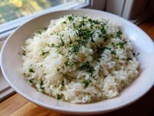 A bowl of fluffy Mediterranean lemon rice generously topped with fresh chopped parsley and dill.