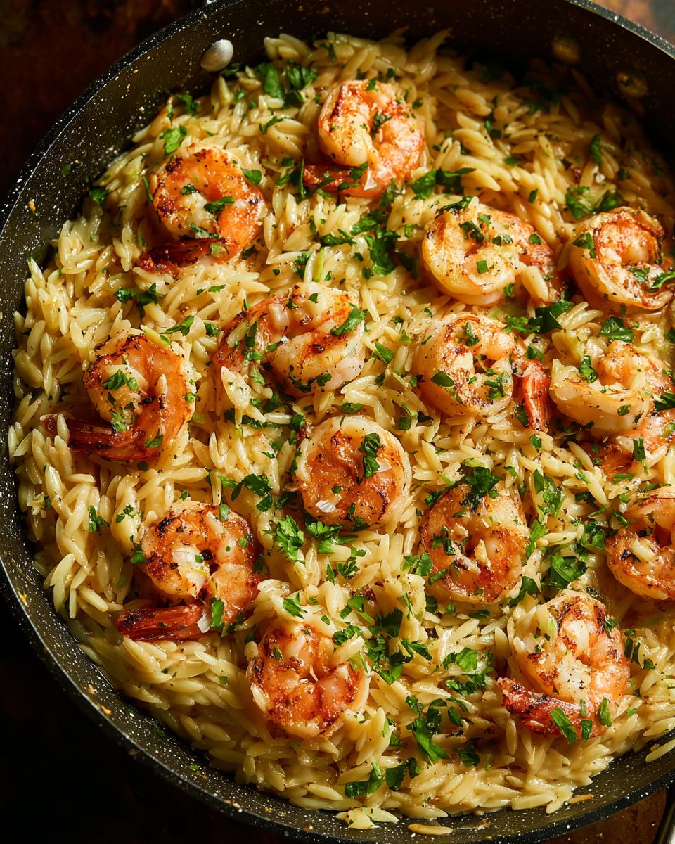 Close-up of shrimp orzo in lemon garlic sauce, garnished with fresh parsley.
