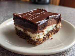 A close-up of a rich Chocolate Dream Bar slice on a plate, showcasing its layered texture.