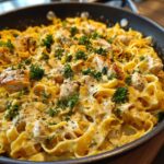 Close-up of creamy Garlic Parmesan Chicken Pasta with tender chicken pieces and fresh parsley in a skillet.