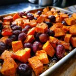 Close-up of caramelized roasted grapes and sweet potatoes cubes fresh from the oven.