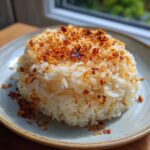 A mound of fluffy butter rice topped generously with golden brown crispy fried garlic bits.