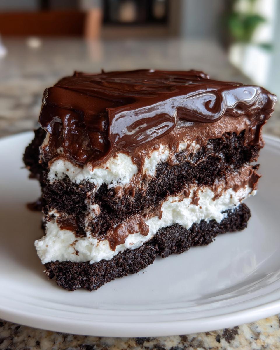 A decadent slice of 4-layer mud pie showing dark chocolate cake, white cream filling, and rich chocolate frosting.