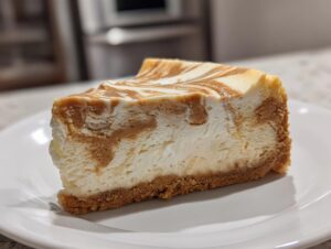 A close-up of a rich slice of sugar cookie cheesecake featuring a graham cracker crust and a marbled top.