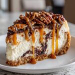 A rich slice of turtle cheesecake topped with pecans, chocolate swirl, and dripping caramel sauce.