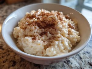 Close-up of a bowl of creamy rice pudding generously sprinkled with ground cinnamon.