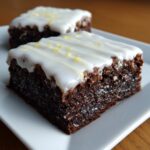 Close-up of two fudgy Lemon Brownies topped with white glaze and lemon zest.