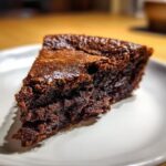 Close-up of a rich, dark slice of fudge pie showing its dense, gooey texture.