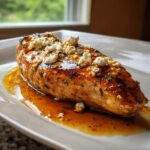 A juicy chicken breast coated in a glossy hot honey glaze and topped with crumbled feta cheese, part of the hot honey feta chicken recipe.
