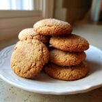 A stack of six chewy maple brown sugar cookies coated in sparkling sugar crystals on a white plate.