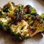 Close-up of perfectly roasted broccoli florets with dark, crispy edges and seasoning.