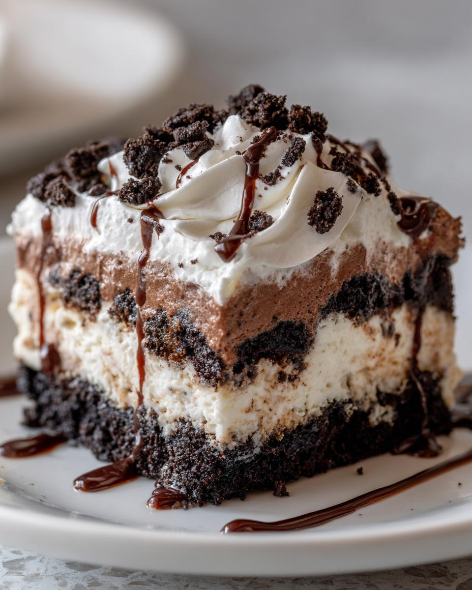 Close-up of a decadent slice of Baileys Chocolate Cheesecake Trifle with layers of cream and chocolate crumbs.
