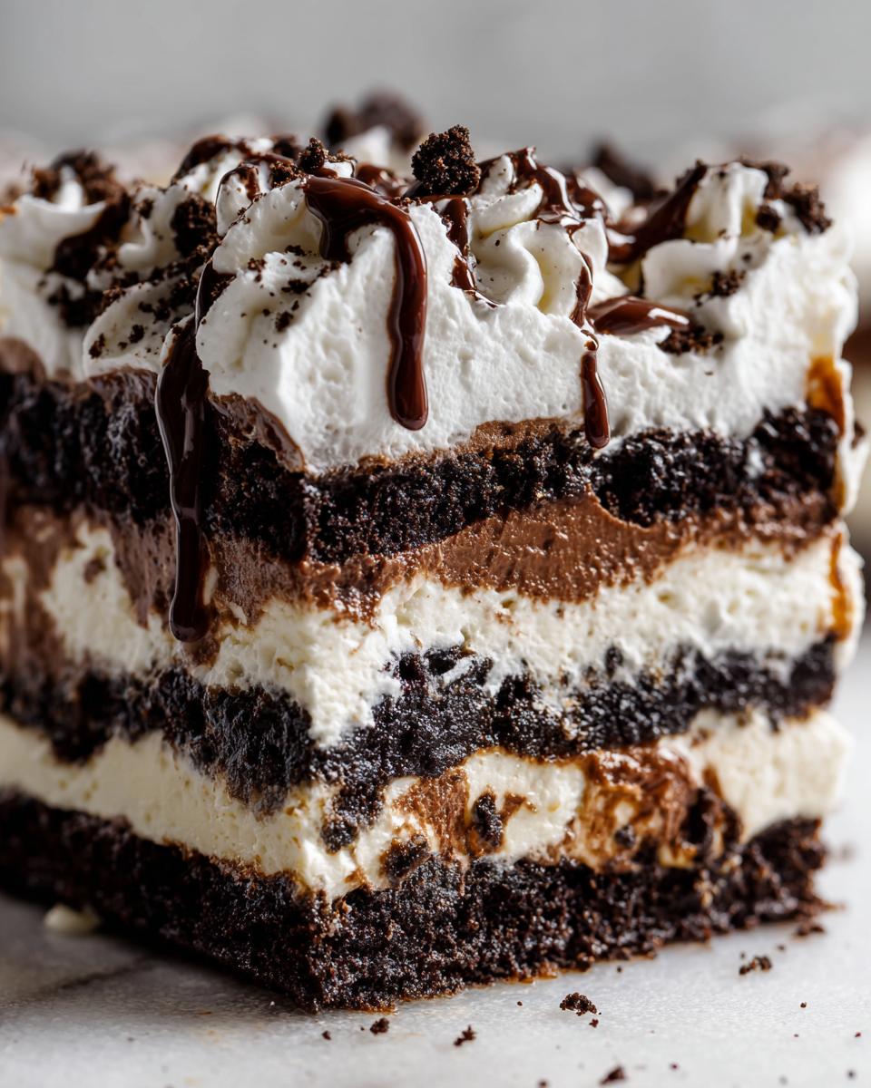Close-up of a layered slice of Baileys Chocolate Cheesecake Trifle showing dark chocolate cake, creamy filling, and whipped topping.
