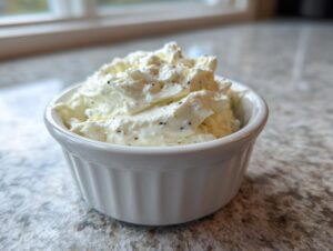 A close-up of creamy, white horseradish sauce speckled with pepper in a small white ramekin.