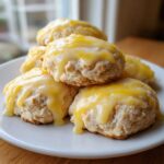 A stack of fluffy ricotta cookies topped with a thick, dripping lemon glaze.
