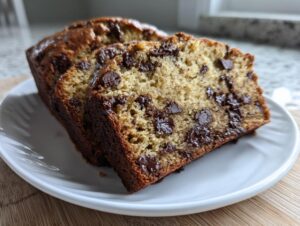 Three moist slices of chocolate chip banana bread recipe displayed on a white plate.