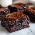 A close-up, tempting shot of a fudgy zucchini brownies square showing melted chocolate chips.