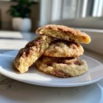 A stack of three soft, thick Gilmore Girls coffee cake cookies topped with cinnamon streusel, one broken open to show the texture.