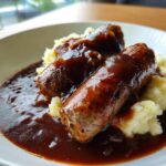 Two grilled sausages smothered in rich brown onion gravy served over creamy mashed potatoes, classic bangers and mash.