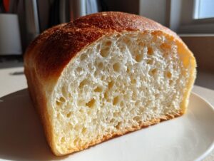Close-up of a sliced loaf of amazing yeast bread showing its fluffy, open crumb structure and golden crust.