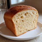 Cross-section of a fluffy loaf of homemade yeast bread showing the soft interior crumb and golden crust.