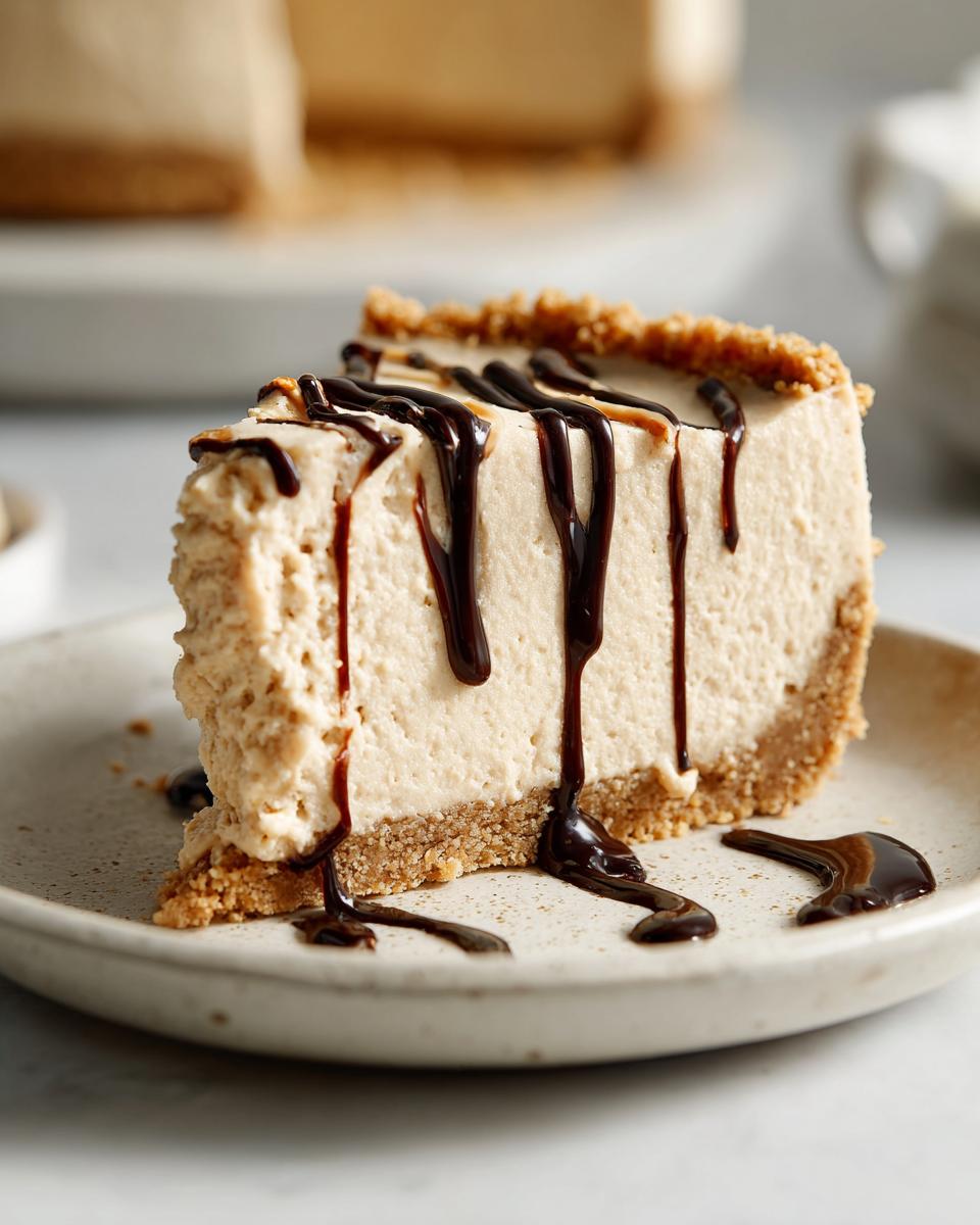 A close-up of a creamy slice of no bake peanut butter pie topped with rich chocolate syrup drizzled down the sides.